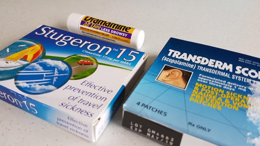 Three types of motion sickness remedies laid out on a counter, including Stugeron 15 tablets, a Dramamine All Day Less Drowsy tube, and Transderm Scop scopolamine patches. These are common treatments for preventing nausea and dizziness during an Antarctica cruise.