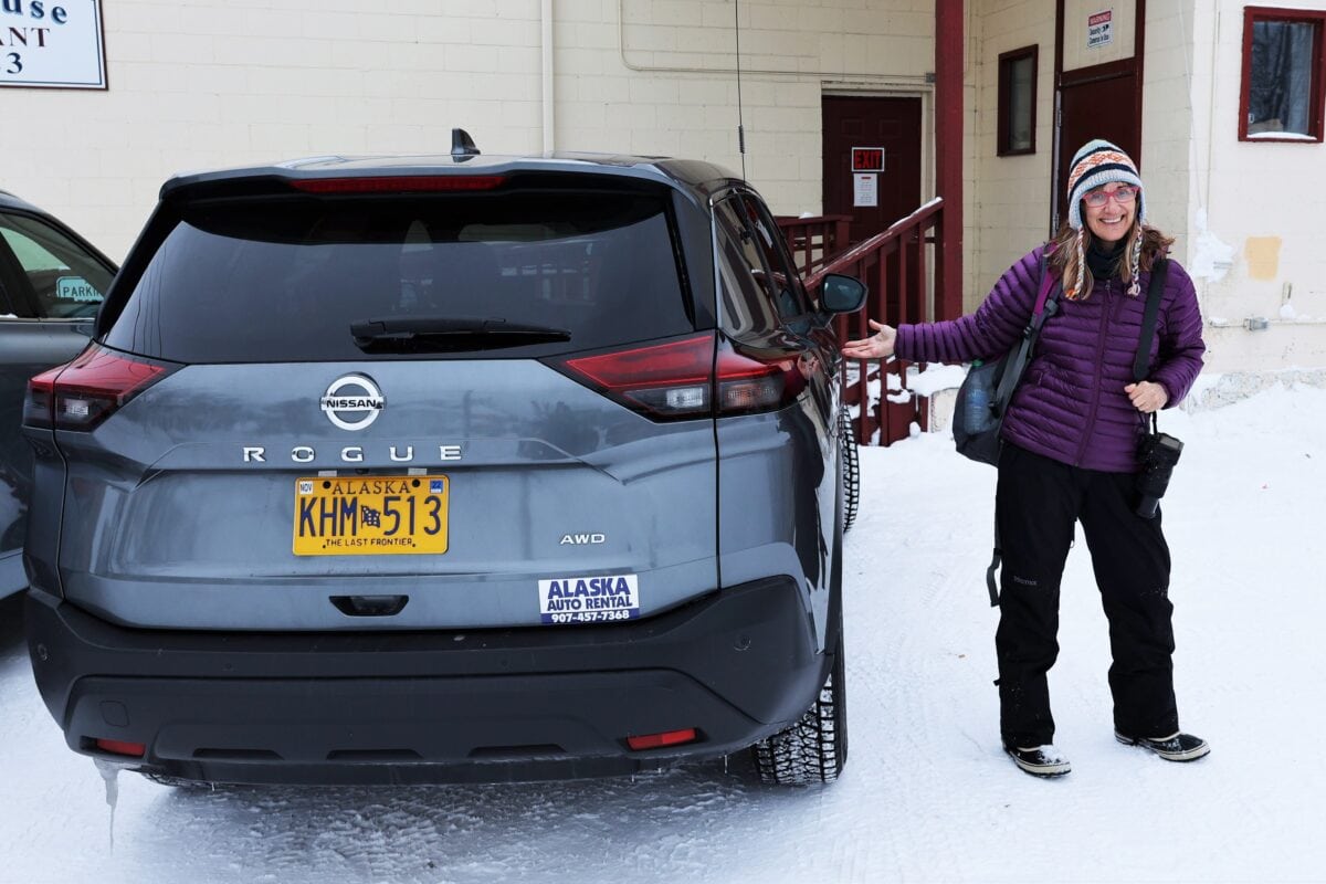 Author standing next to rented Nissan as she learns about driving in winter in Fairbanks